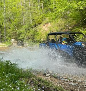 a blue atv driving through the water on a dirt road