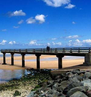 站在海滩上码头上的一个人