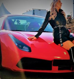 a woman sitting on top of a red car