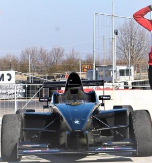 two women standing next to a race car