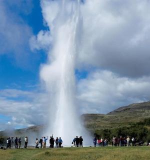 a group of people standing in front of a waterfall