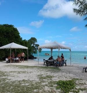 一群人坐在沙滩上的遮阳伞下