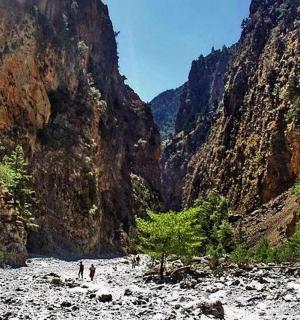 dva lidé procházející řekou v kaňonu