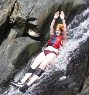 一名女子躺在瀑布的岩石上