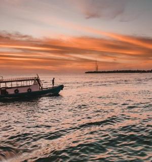 a boat in the water with a sunset