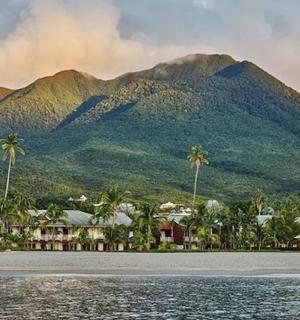 一座山,山上有棕榈树,水边有房屋