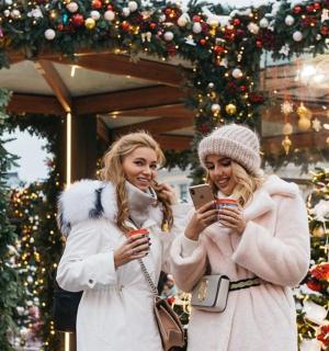 dvě ženy stojící před vánoční výzdobou