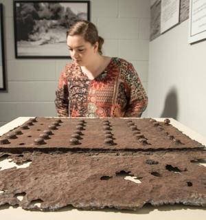 žena se dívá na velký čokoládový dort na stole