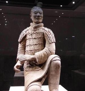 a statue of a man sitting down in a display case