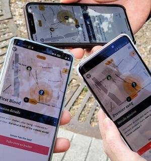 三个人手里拿着三部手机