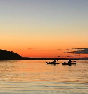 日落时分,两个人在水上的船上