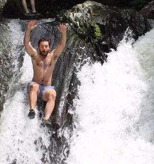一名男子坐在瀑布顶上