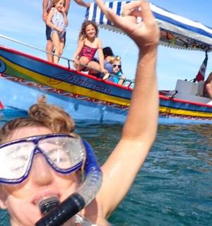 eine Frau im Wasser mit einem Mikrofon vor einem Boot