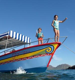 zwei Mädchen stehen auf der Vorderseite eines Bootes im Wasser