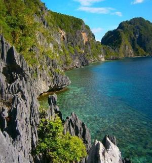 a view of a rocky mountain next to the water