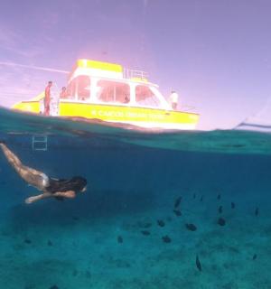 一名男子在船旁的海里游泳