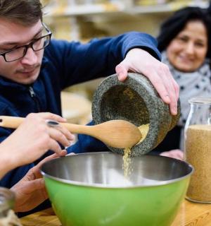 a man mixing ingredients in a bowl with a woman
