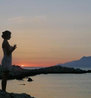 žena stojící na pláži při západu slunce