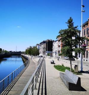 河上的一座桥，旁边有一栋建筑，旁边有长椅