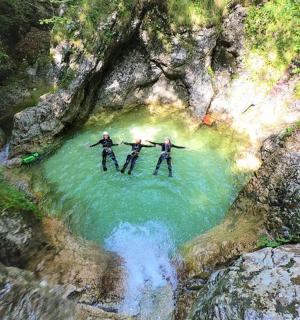 Tři lidé stojí ve vodě v řece