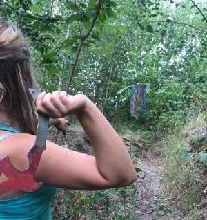 en kvinde, der holder en kniv i skoven