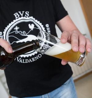 一名男子将一瓶啤酒倒入玻璃杯中