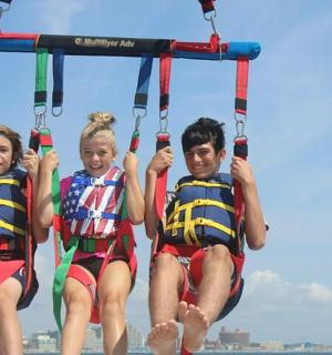 三个人在海滩上玩滑索