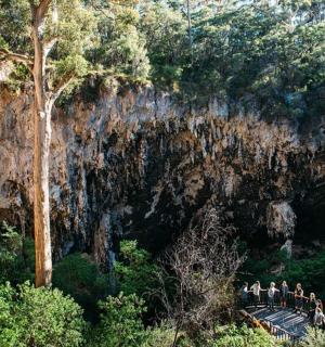 一群人站在山前的一座桥上