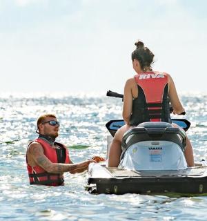 a man and a woman on a speed boat in the water