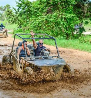 two men riding a dirt car in the mud