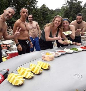 a group of people standing around a table with food on a surfboard