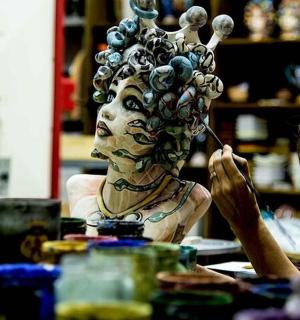 一位女士正在为一位长着头发的女士雕像作画