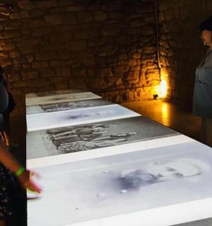 en gruppe mennesker, der står omkring et bord med fotografier på