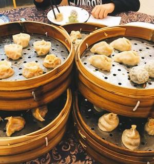 two buckets filled with dumplings sitting on a table