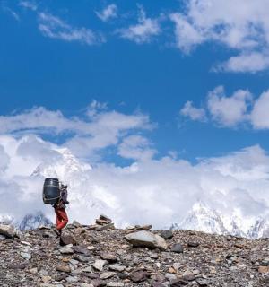 背着背包站在岩石山上的人