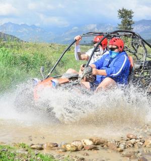 a group of people on an atv crossing a river