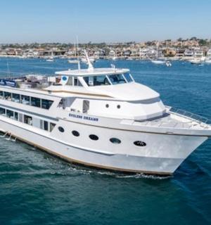 bílá loď na vodě s městem v pozadí