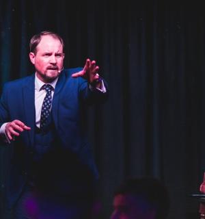 a man in a suit and tie standing on a stage