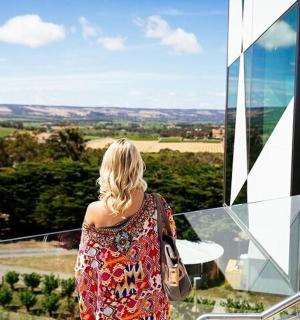 a woman standing on a balcony looking out at the countryside