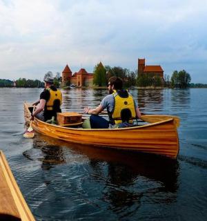 two people in a wooden boat on the water