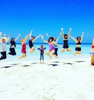 a group of people jumping on the beach