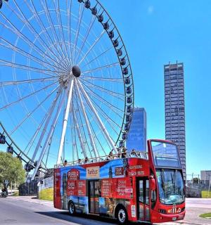 红色巴士旁边的大型摩天轮