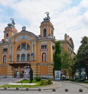 ein großes gelbes Gebäude mit Statuen darauf