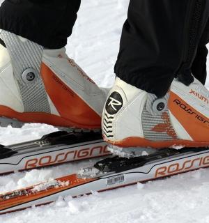 一个人站在雪地里的滑雪板上