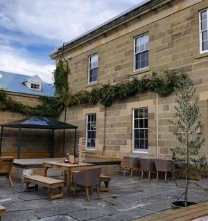 a patio with tables and chairs next to a brick building