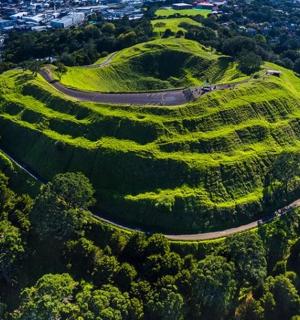 一座长满草的小山，山上有一条蜿蜒的道路