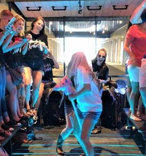 a girl is walking in front of a group of people