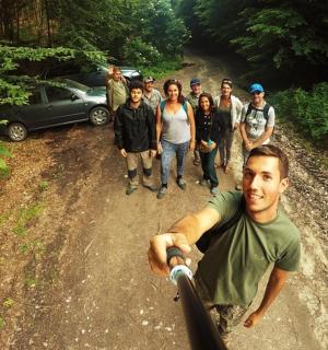 un grup de oameni care stă pe un drum de pământ cu un bărbat pe o bicicletă