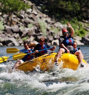 a group of people in a yellow raft on a river