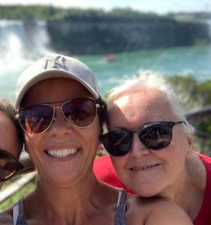 three women posing for a picture in front of waterfall
